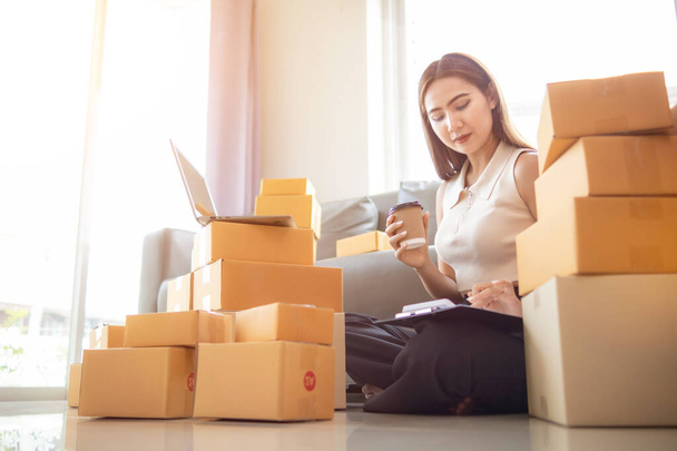 small sme entrepreneur is packing products into parcel boxes in preparation for transporting them to freight forwarder to deliver to customers with incoming orders. Concept Ecommerce Team online sales - Photo, Image
