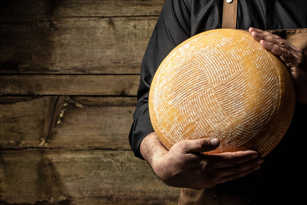 Cheesemaker contrôle les assaisonnements de nombreuses roues de fromage. mains masculines tenant différents types de fromage. - Photo, image