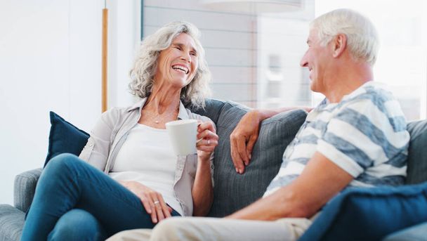 Jääkää eläkkeelle ja tutustukaa toisiinne. vanhempi pari nauttimassa rentouttavasta kahvitauosta kotona sohvalla - Valokuva, kuva