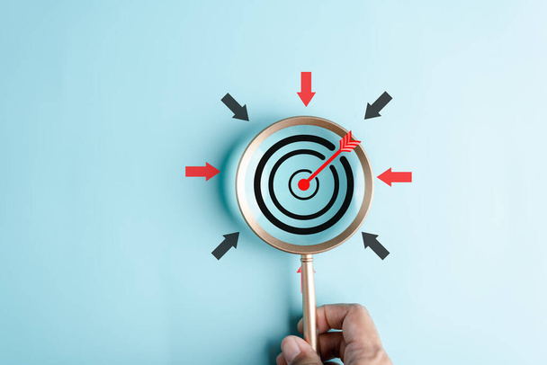 Magnifier glass focus to target icon with arrow to planning and management business development leadership and customer target group. - Foto, Bild