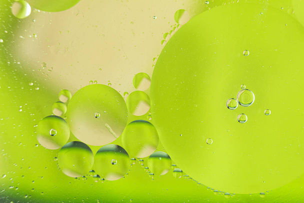 Fond abstrait, bulles d'air en gros plan sur l'eau. Macro photo de l'eau et de l'huile. Étranges métamorphoses de ballons dans l'eau. Belle et fantastique macro shot de gouttes d'eau dans l'huile avec fond coloré - Photo, image