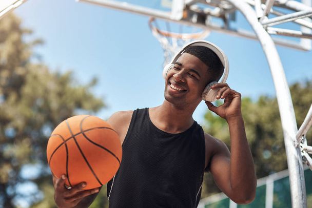 Esta compota é tão boa. um jovem desportivo ouvindo música enquanto joga basquete em uma quadra de esportes - Foto, Imagem