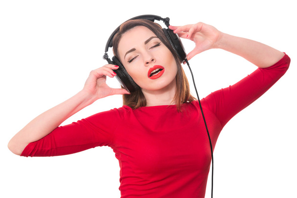 Pretty girl with red lipstick and red clothes listening to the m - Foto, imagen
