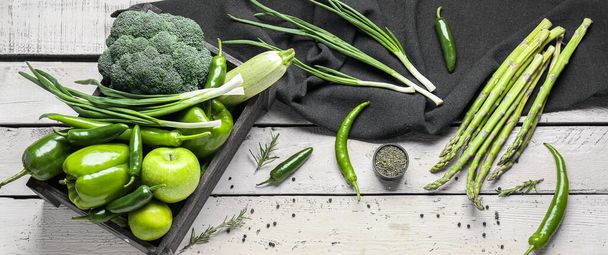 Состав с различными зелеными овощами и фруктами на светлом деревянном фоне - Фото, изображение