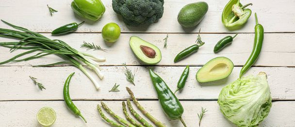 Many green vegetables and fruits on light wooden background, top view - Zdjęcie, obraz