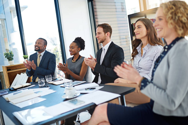 A dar uma merecida salva de palmas. um grupo de empresários corporativos aplaudindo enquanto sentados na sala de reuniões - Foto, Imagem