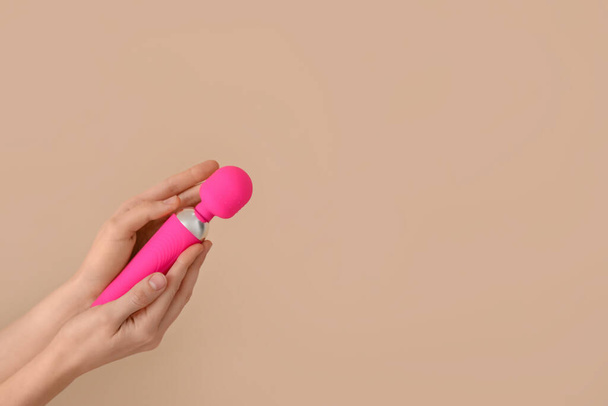Woman with pink vibrator on beige background - Foto, Imagen