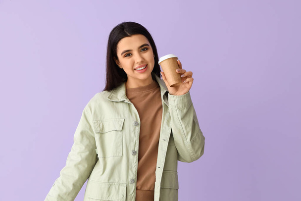Mujer bastante joven bebiendo café sobre fondo lila - Foto, Imagen