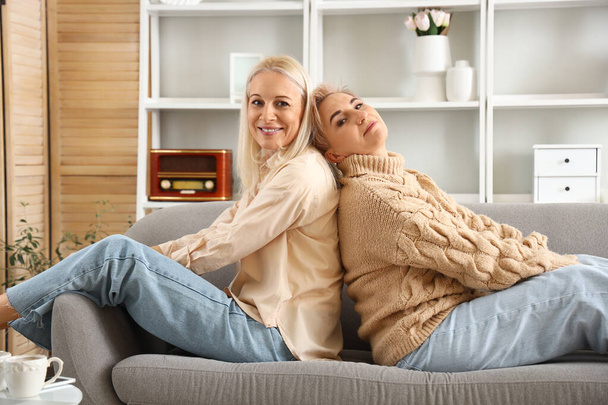 Onnellinen kypsä naiset istuu sohvalla kotona - Valokuva, kuva