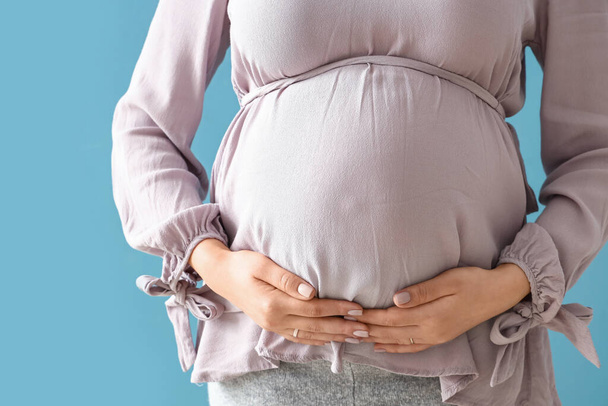 Young pregnant woman on blue background, closeup - Photo, Image