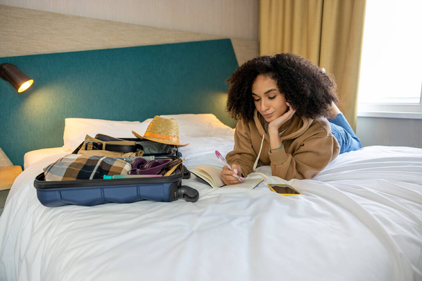 Selfie. Cute young woman making slefie on the bed in the hotel - 写真・画像
