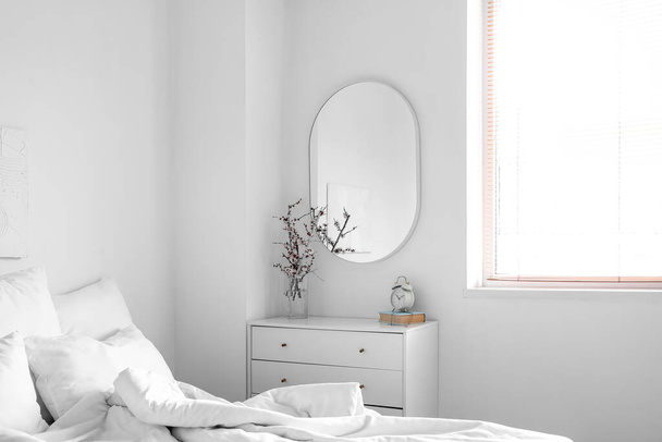 Interior of light bedroom with mirror and commode - Photo, Image