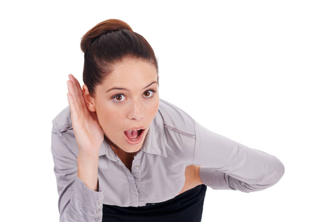 She cant believe what she is hearing. Studio portrait of a surprised-looking young business woman cupping her hand to her ear isolated on white - Foto, Imagem