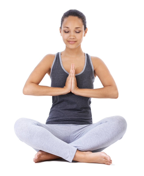 Thinking calm thoughts. A beautiful young woman doing a yoga pose against a white background - Photo, image