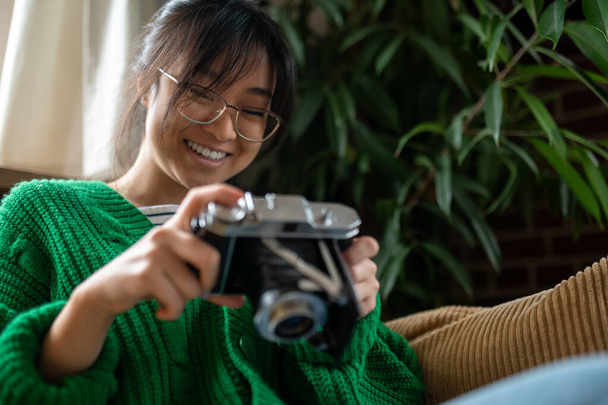 Photographer. Smiling asian young girl with an old-fashioned camera - Fotografie, Obrázek