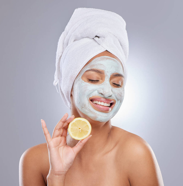 C vitamini leke çıkarmada yardımcı olur. Yüz maskesi takan ve stüdyoda limon tutan çekici bir genç kadın. - Fotoğraf, Görsel