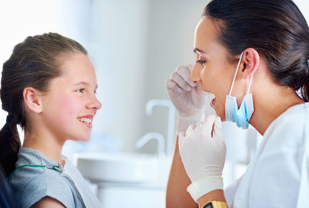 Eine kurze Lektion in Zahnseide. Zahnärztin mit Kind in Zahnarztpraxis - Foto, Bild
