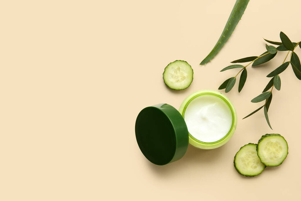 Jar of natural cream, cucumber slices and eucalyptus branch on color background - Photo, Image