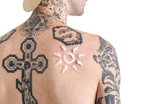 Tattooed man with sunscreen cream on his skin against white background, closeup - Zdjęcie, obraz