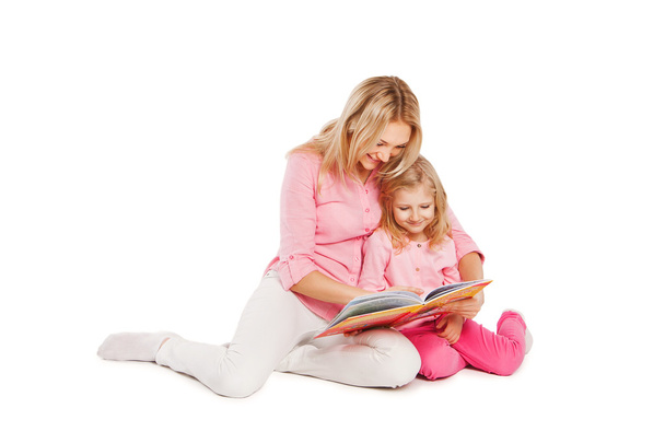 Happy mother and child reading a book together on white - Фото, зображення