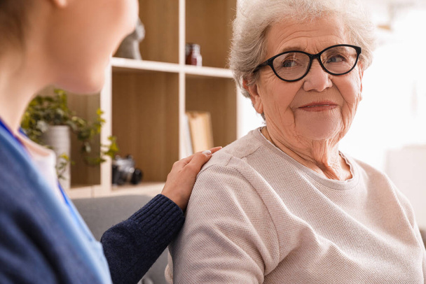Idős nő gondozójával otthon, közelkép - Fotó, kép