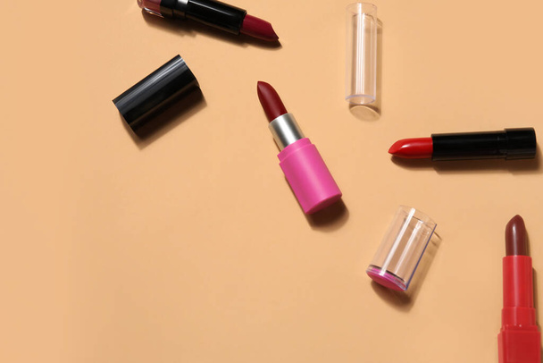 Different lipsticks on beige background - Fotografie, Obrázek