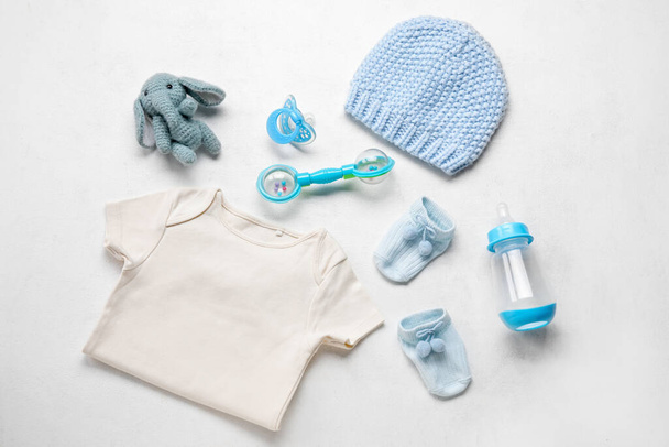 Composición con ropa de bebé, juguete y accesorios sobre fondo blanco - Foto, imagen