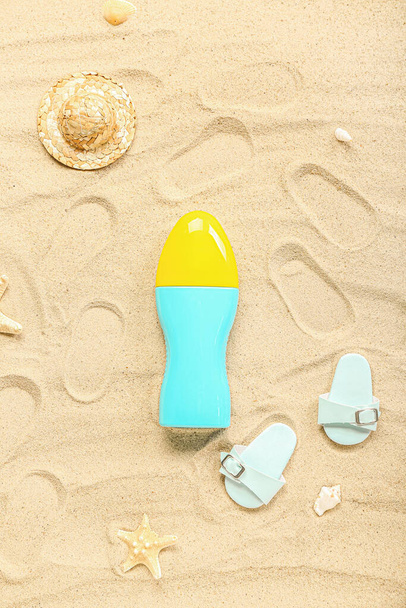 Kreatív kompozíció naptejszínnel, papuccsal és nyári homoksapkával - Fotó, kép