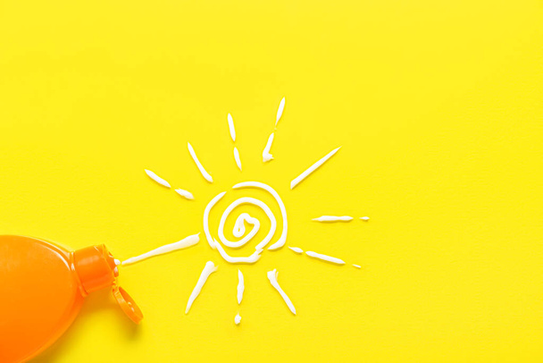 Drawing of sun made with sunscreen cream on yellow background - Photo, Image