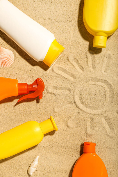Kreative Komposition mit Rahmen aus verschiedenen Sonnencremes auf Sand - Foto, Bild