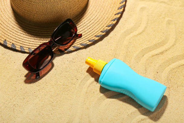 Composition créative avec crème solaire et accessoires de plage sur sable - Photo, image