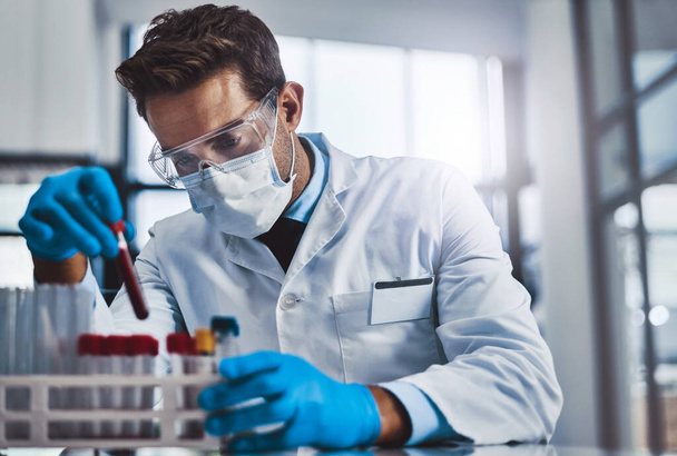 У медицины есть способность улучшать мир. молодой ученый-мужчина, работающий в лаборатории - Фото, изображение