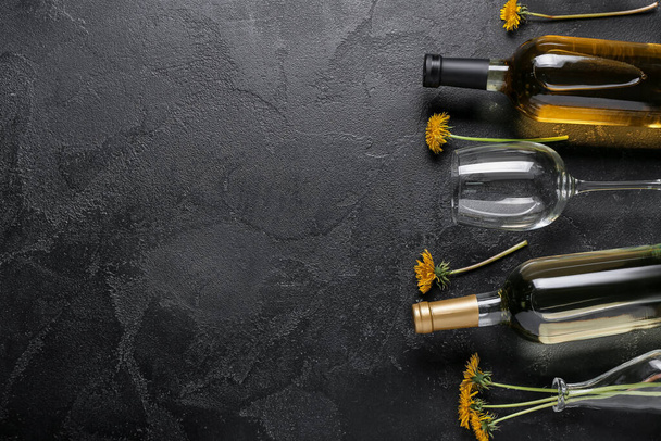 Bottles and glass of dandelion wine on black background - Фото, зображення
