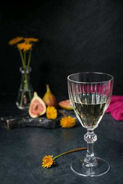 Glass of dandelion wine on dark table - Photo, Image