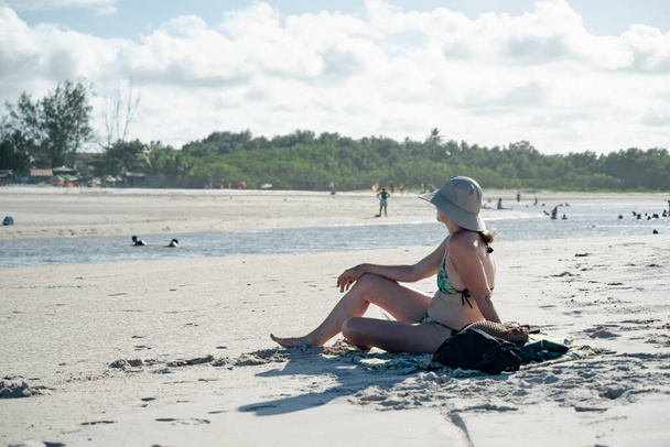 Kumsalda güneşlenen bir kadın. Taquari, Guaibim plajı, Valenca, Bahia. - Fotoğraf, Görsel