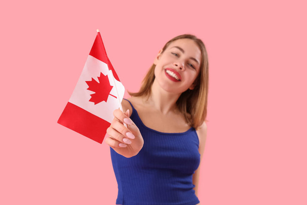 Молодая женщина с флагом Канады на розовом фоне - Фото, изображение