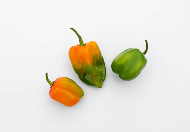 Different fresh raw hot chili peppers on white background, flat lay - Fotografie, Obrázek