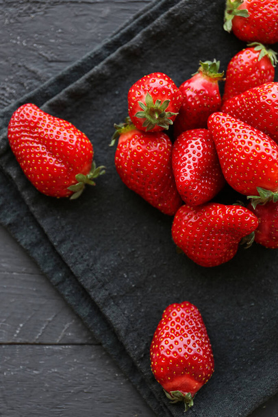 Fresh strawberries on black wooden background - 写真・画像