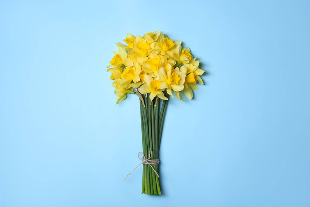 Bouquet of beautiful yellow daffodils on light blue background, top view - Zdjęcie, obraz