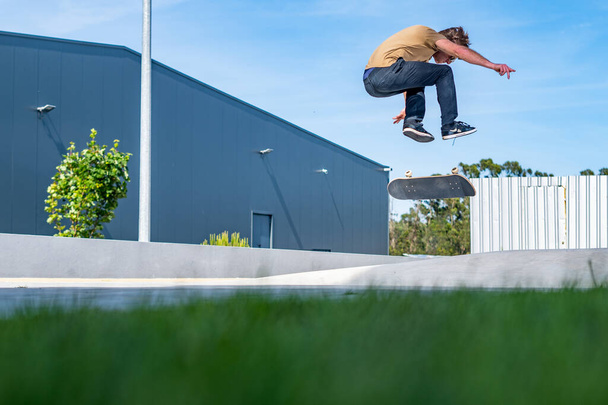 Skateboarder doing a flip trick  on a urban scene. - Фото, изображение