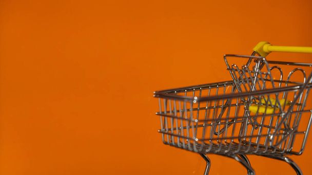 Oranžová prázdná obrazovka notebooku s nákupním košíku. E-commerce Online nákupní webové stránky. Kopírovat prostor pro text. Vysmívat se internetovému obchodu. Nákupní vozík e market - Fotografie, Obrázek