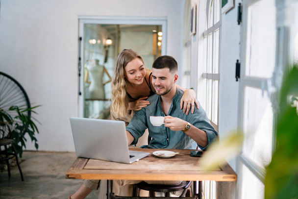 Happy young couple married spouse web surfing, making purchases online or booking flight tickets. The concept of couples sharing one idea together. - Zdjęcie, obraz