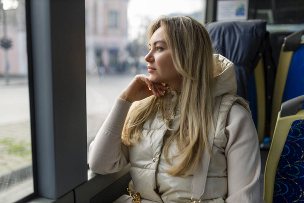 Pretty girl looking out the bus window .  - Foto, afbeelding