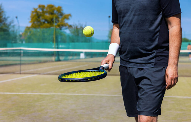 tennisspeler stuiteren de bal op racket op outdoor game court - Foto, afbeelding
