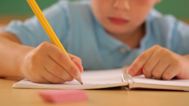 Child writing at school - Filmati, video