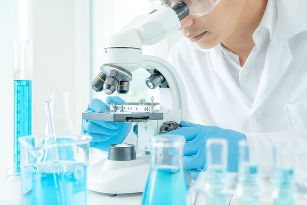科学者は最先端の科学研究室で生化学試料を分析する。医療用顕微鏡はウイルスの微生物学的発達に見える。科学研究所のバイオテクノロジー研究. - 写真・画像