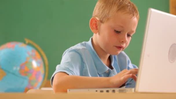 Boy typing on laptop computer - Felvétel, videó