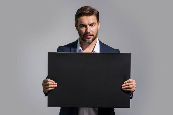 Serious business man holding empty board. Successful businessman showing blank signboard with copyspace. Idea and offer. Your advertisement. Blank advertising board with empty space for text, mockup - Φωτογραφία, εικόνα