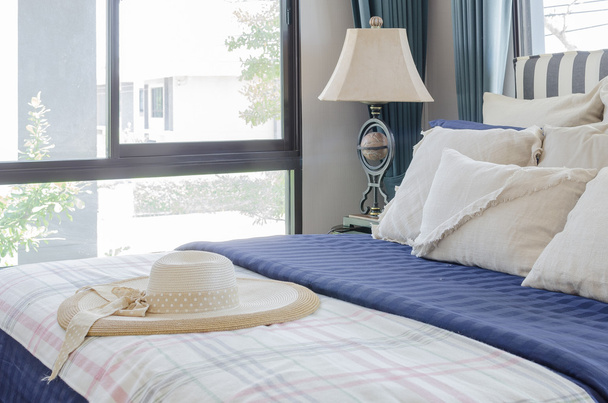 капелюх на ліжку з подушками в сучасній спальні
 - Фото, зображення