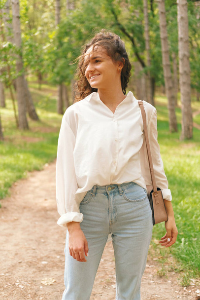 Ofiste yorucu bir günün ardından genç kadın rüzgarlı bir günde ormanda yürüyüşe çıkıyor.. - Fotoğraf, Görsel